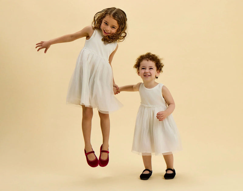 Children jumping wearing Ten Little Velvet Ballet Flats - Burgundy Red and Classic Black. Available from www.tenlittle.com