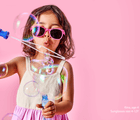 Girl age 4 playing with bubbles wearing Ten Little Sunglasses size 4-12Y - Glitter Pink. Available at www.tenlittle.com