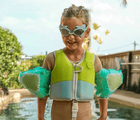 Child by the pool wearing Sunnylife Shark Float Vest. Available from www.tenlittle.com