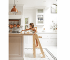 Child using the Piccalio Foldable Kitchen Tower to play with fruits on the kitchen counter. Available from www.tenlittle.com