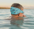 Boy swimming with Splash Place Shark Tangle-Free Swim Goggles. Available from www.tenlittle.com