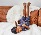 Boy at the coach wearing Ten Little Cozy Slippers. Available at www.tenlittle.com