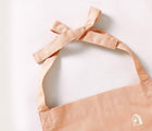Close up of tied apron in the Piccalio Mini Chef Apron & Hat Set in pink. Available from www.tenlittle.com