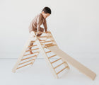 Side view of child playing on the Piccalio Climber Pikler Triangle Set. Available from www.tenlittle.com