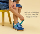 Child putting on Ten Little Retro Suede Sneakers - Retro Blue. Available at www.tenlittle.com