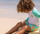 Boy at beach wearing Snapper Rock UPF 50+ Top & Swim Shorts - Lobsters. Available at www.tenlittle.com