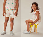 Split view of child wearing Ten Little Slip-On Sneakers - Moondust Silver. Available at www.tenlittle.com