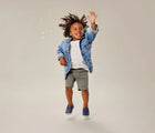 Child playing with bubbles wearing Ten Little Slip-On Sneakers - Navy Blue. Available at www.tenlittle.com