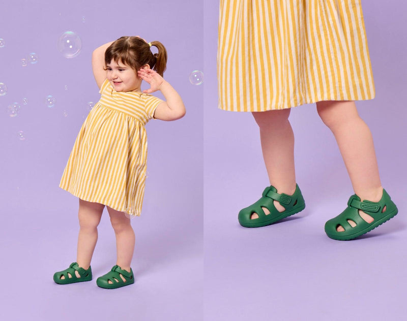Split view of girl playing with bubbles and wearing Ten Little Splash Sandals 2 - Dino Green. Available at www.tenlittle.com