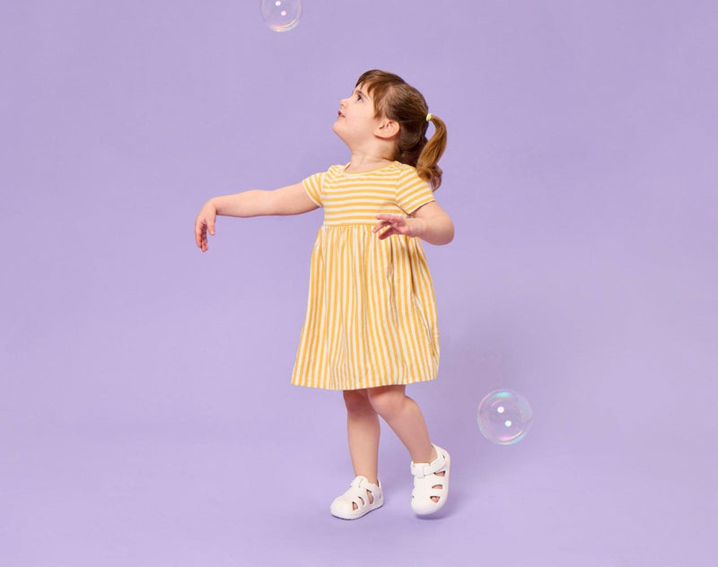 Girl playing with bubbles wearing Ten Little Splash Sandals 2 - Soft White. Available at www.tenlittle.com