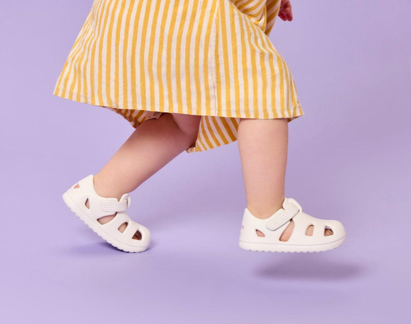 Side view of girl wearing Ten Little Splash Sandals 2 - Soft White. Available at www.tenlittle.com
