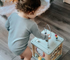 Child playing with Bigjigs Wooden Activity Cube. Available from www.tenlittle.com.
