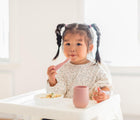 Baby Holding Ezpz Mini Utensils set of 2 in blush- Available at www.tenlittle.com