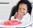 Baby Holding Ezpz Tiny Cup Coral with Coral Tiny bowl.  Available at www.tenlittle.com