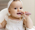 Child using the tiny development tool from ezpz Oral Development Tools in blush. Available from tenlittle.com