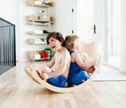 Two children playing on All Circles Balance Board & Rocker in a playroom. Available from tenlittle.com