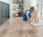 Child climbing down All Circles Balance Board & Rocker in a playroom. Available from tenlittle.com