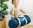 Baby Holding Bag of Bloomere Back to School Nap Mat Navy- Available at www.tenlittle.com