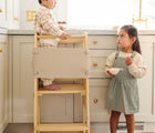 Child standing on the Convertible Kitchen Tower with safety net. Available from www.tenlittle.com
