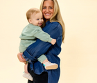 Mom holding baby wearing Ten Little Everyday Baby Booties - Heather Oat. Available at www.tenlittle.com