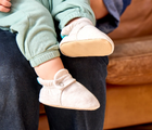 Side and bottom grippy outsole view and baby wearing Ten Little Everyday Baby Booties - Heather Oat. Available at www.tenlittle.com