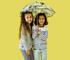 Children holding the Floss & Rock Color Changing Umbrella - Dino. Available from www.tenlittle.com