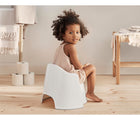 Little girl sitting BabyBjorn Potty Chair - Gray/White - Available at www.tenlittle.com