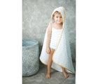Little Girl standing and wearing Malabar Baby Hooded Block Print Towel- Yellow - Available at www.tenlittle.com