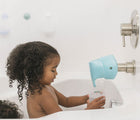 Baby girl at the tub using Puj Faucet Spout Cover- Available at www.tenlittle.com