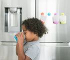 Boy drinking Puj Grippy Bath Treads- Available at www.tenlittle.com