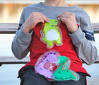 Child holding Keep>Going Gel Ice Packs - Dinosaur. Available at www.tenlittle.com