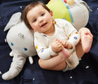 Baby lying at the Plan Toys Elephant Activity Pillow - Available at www.tenlittle.com