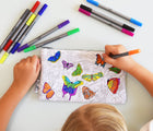 Child coloring in eatsleepdoodle Butterfly Pencil Case Color and Learn. Available from www.tenlittle.com.
