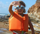 Child at beach wearing the Sunnylife Sea Creature Float Vest (Ages 2-3) - Crab. Available from www.tenlittle.com