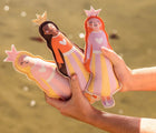 Child at the beach holding the Sunnylife Princess Swan Dive Buddies. Available from www.tenlittle.com