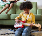 Boy playing with Loog Mini Electric Guitar - Red - Available at www.tenlittle.com