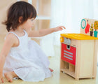 Girl playing Plan Toys Compact Kitchen Set - Available at www.tenlittle.com