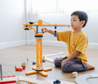 Boy playing with Plan Toys Crane Set - Available at www.tenlittle.com