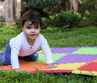 Boy crawling on Edushape Soft Tile Play Mat in the backyard. Available from www.tenlittle.com.