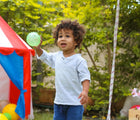 Boy playing in the backyard with Edushape Sensory Balls. Available from www.tenlittle.com.