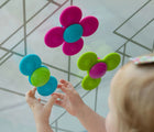 Child playing with Fat Brain Toys Whirly Squigz. Available from www.tenlittle.com.