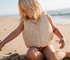 Child playing on the sand in the Sunnylife Swan Float Vest. Available from www.tenlittle.com