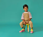 Boy sitting and wearing Limited Edition Everyday Original x2 in Pink and Yellow toddler kid shoes. APMA approved. Available at www.tenlittle.com