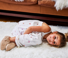 Kid lying at the carpet wearing Ten Little Cozy Slippers. Available at www.tenlittle.com
