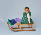 Girl riding at the snow sled wearing Ten Little Snow Bootsin Navy and Teal. Available at www.tenlittle.com