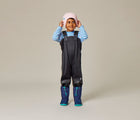 Kid wearing Ten Little boots and hat with Therm Eco Waterproof & Windproof Fleece Overalls - Black - Available at www.tenlittle.com