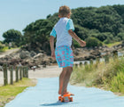 Child skating on a ramp at the beach in the Snapper Rock One piece UPF 50+ Swim Shorts - Lighthouse Island. Available from www.tenlittle.com