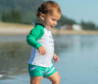 Child in the water wearing the Snapper Rock UPF 50+ Top & Swim Shorts Set. Available from www.tenlittle.com