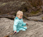Girl Playing sand and wearing Therm SplashMagic Eco Fleece Rain Jacket - Aqua - Available at www.tenlittle.com