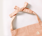 Close up of tied apron in the Piccalio Mini Chef Apron & Hat Set in pink. Available from www.tenlittle.com